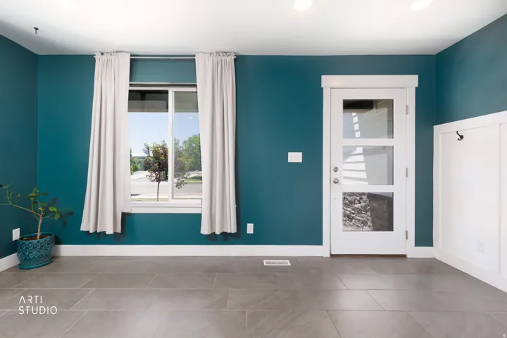 Entryway featuring a white paneled door with three clear glass inserts, complemented by a large window