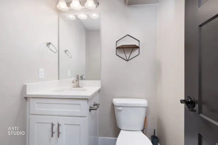 Bathroom featuring a white vanity with a quartz-finish countertop, undermount sink, and brushed nickel fixtures