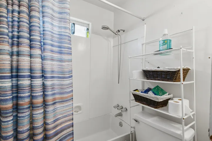 White acrylic bathtub and shower combination with chrome fixtures