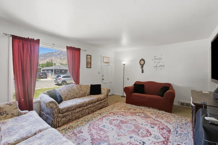 Living area featuring white painted walls and wood-finish flooring