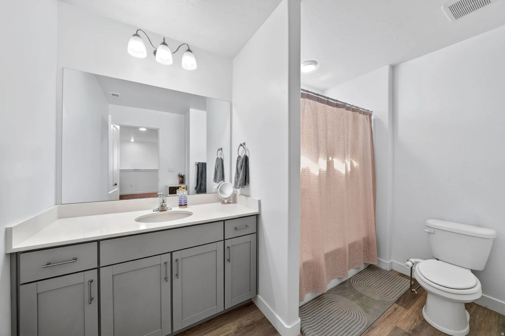 Bathroom featuring a vanity with a white countertop, undermount sink, and gray cabinetry