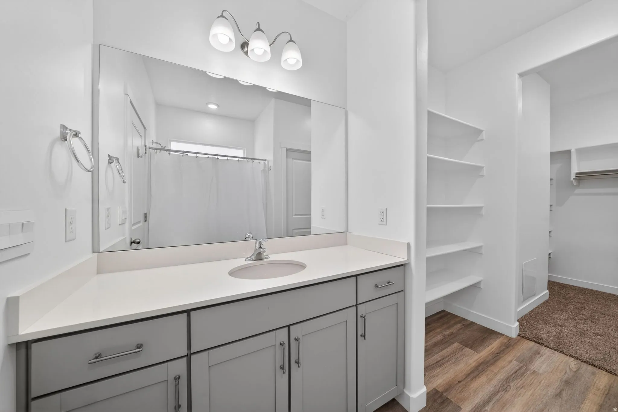 Vanity featuring a light gray base cabinet, white countertop, and integrated sink