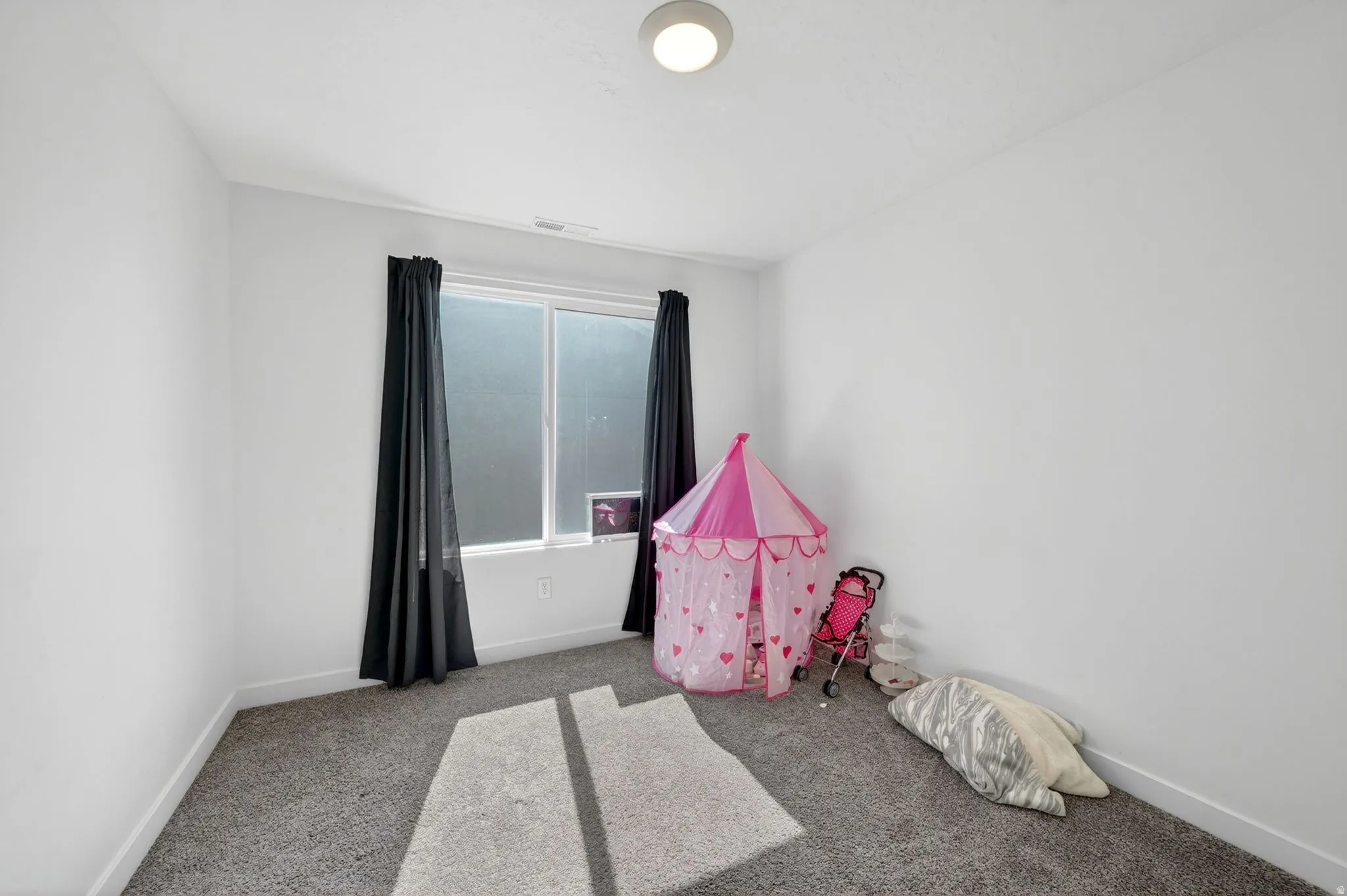 Carpeted room featuring a double window, overhead flush-mount lighting, and white baseboards