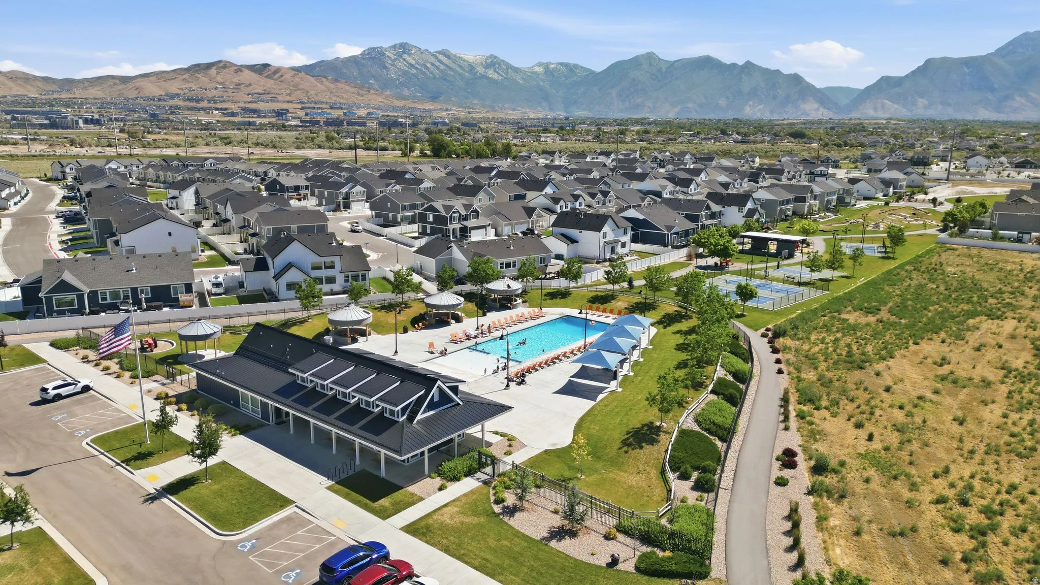 Community clubhouse and swimming pool, surrounded by residential properties and distant mountains