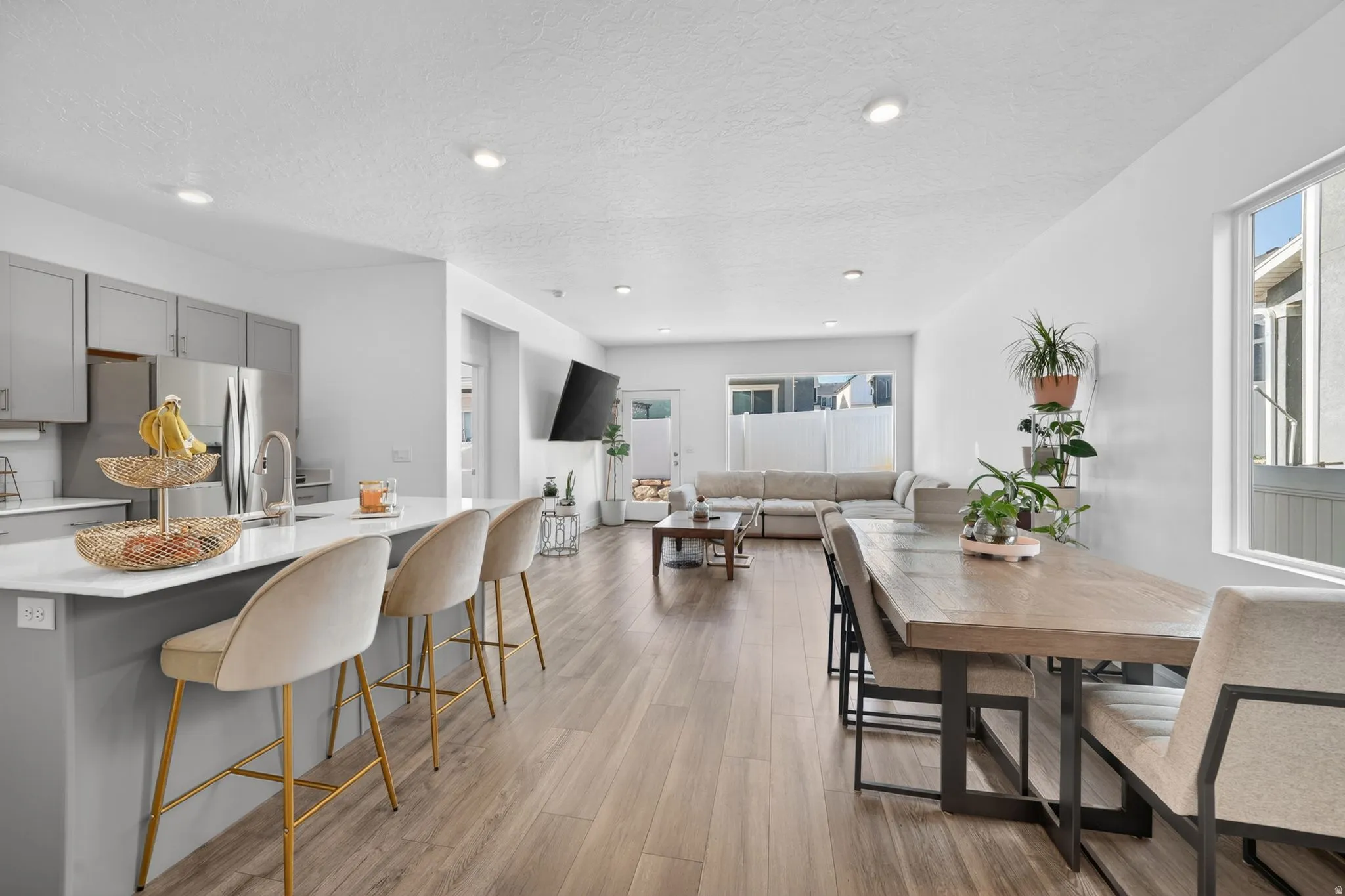 Open-concept living space with wood-finish flooring, recessed lighting, and a kitchen island with seating