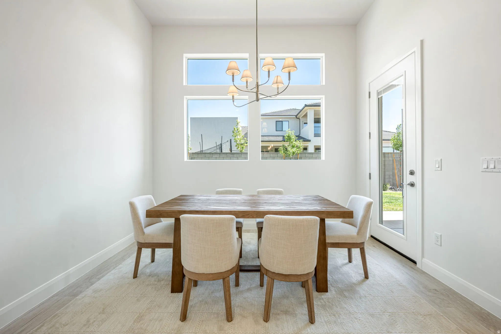 Dining area featuring high ceilings and light-toned wood-finish flooring