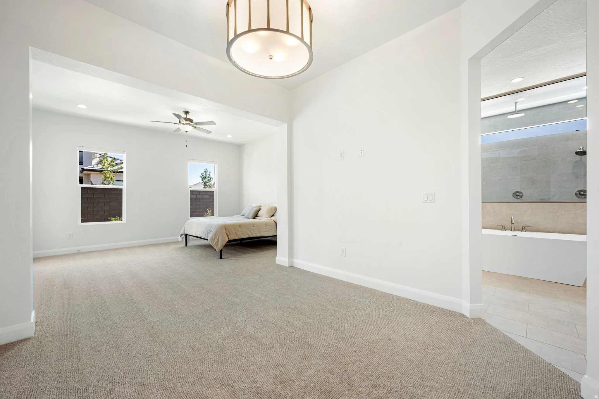 Spacious room with plush carpet flooring and a contemporary drum pendant light fixture