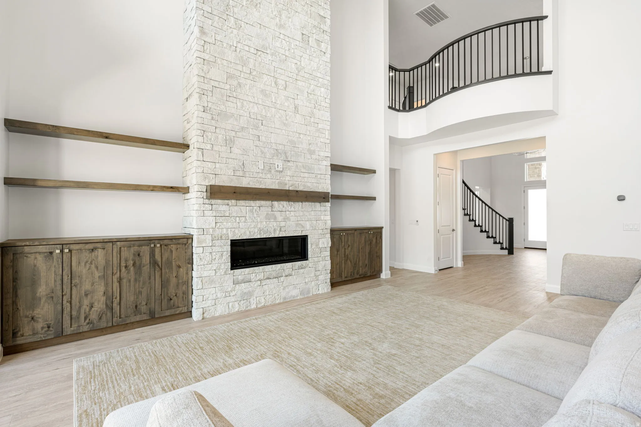 Soaring stone-clad fireplace with a natural wood mantel and linear firebox
