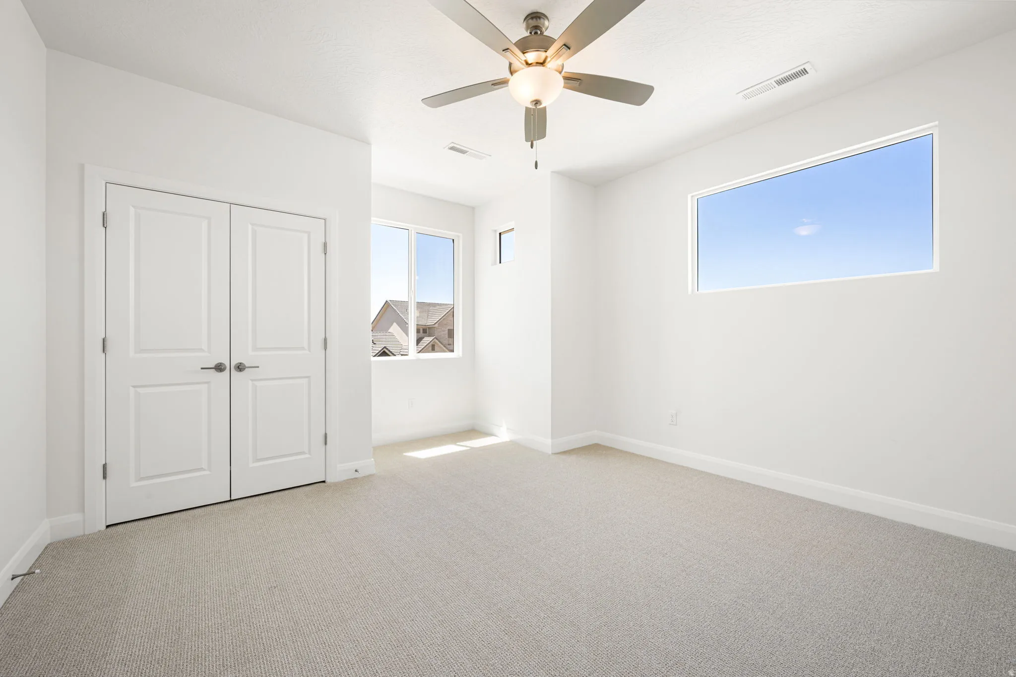 Neutral tone carpeted room with multiple windows