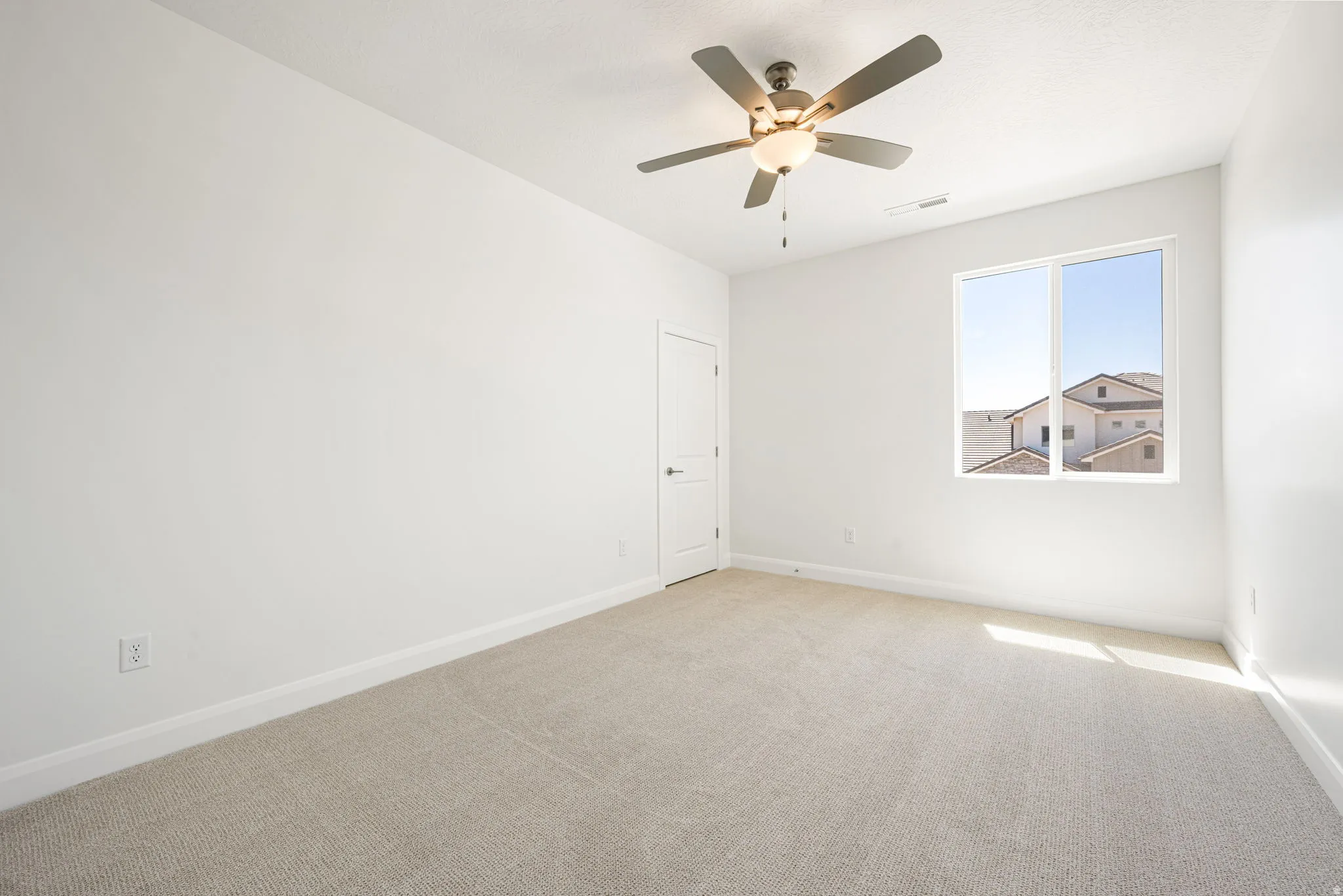 Room with light beige carpet, white walls, and a multi-pane window