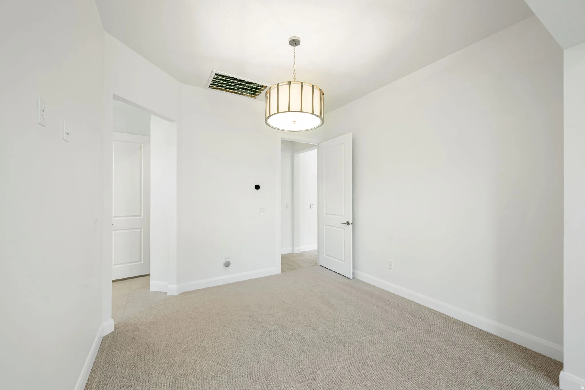 Neutral tone carpeted room featuring a contemporary drum pendant light fixture
