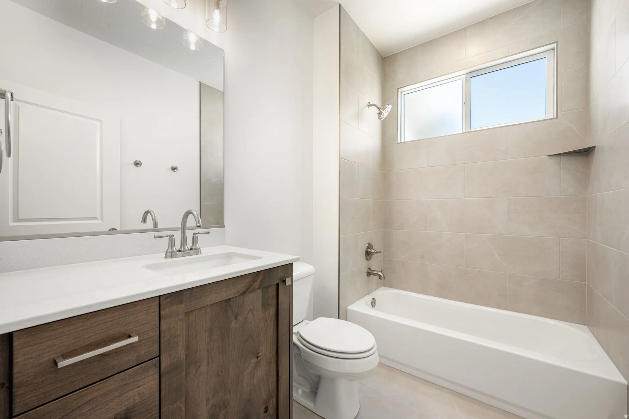 Contemporary bathroom with wood-finish vanity, white countertop, and integrated sink