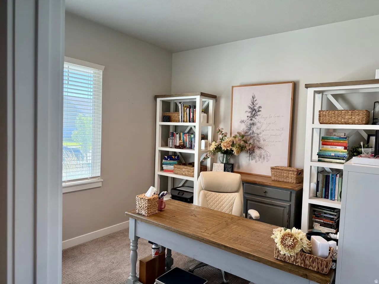 Spacious room featuring neutral-toned walls, a single window with blinds, and built-in shelving units with wood-finish accents