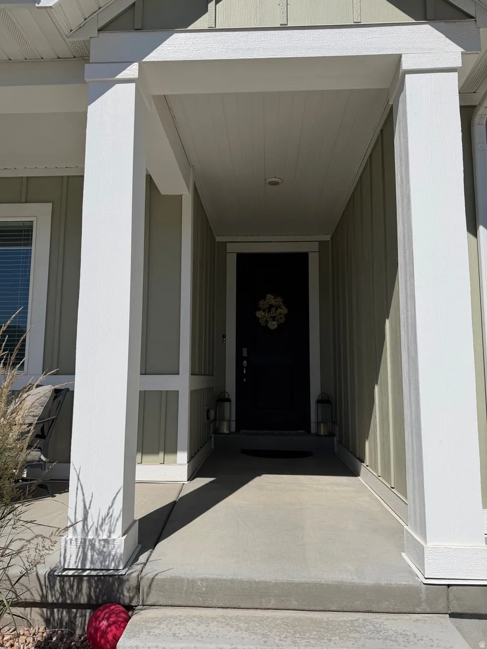 Covered entry with concrete flooring, recessed lighting, and a dark front door