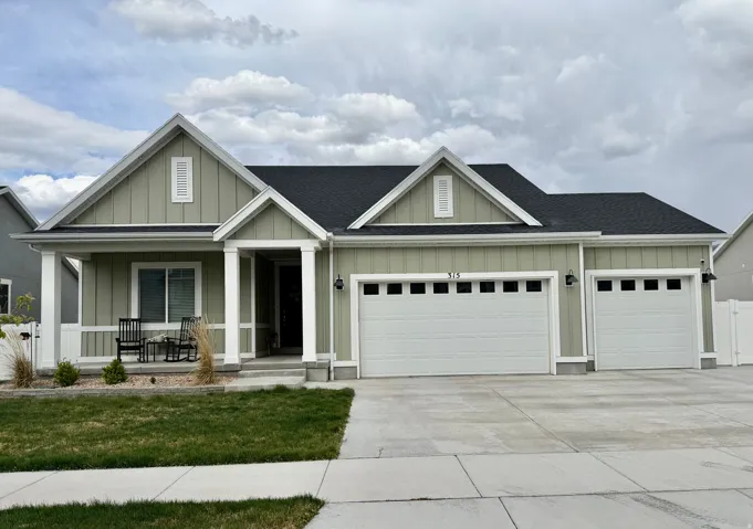 Contemporary ranch-style residence featuring light green board and batten siding with white trim
