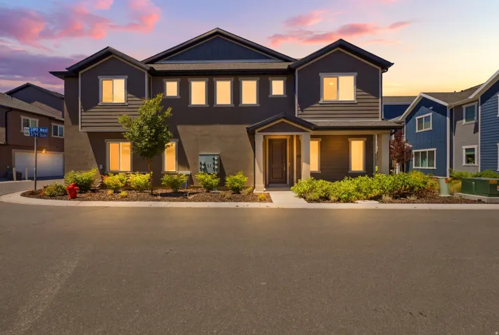 Contemporary two-story residence featuring a dark gray facade with contrasting siding and stucco finishes