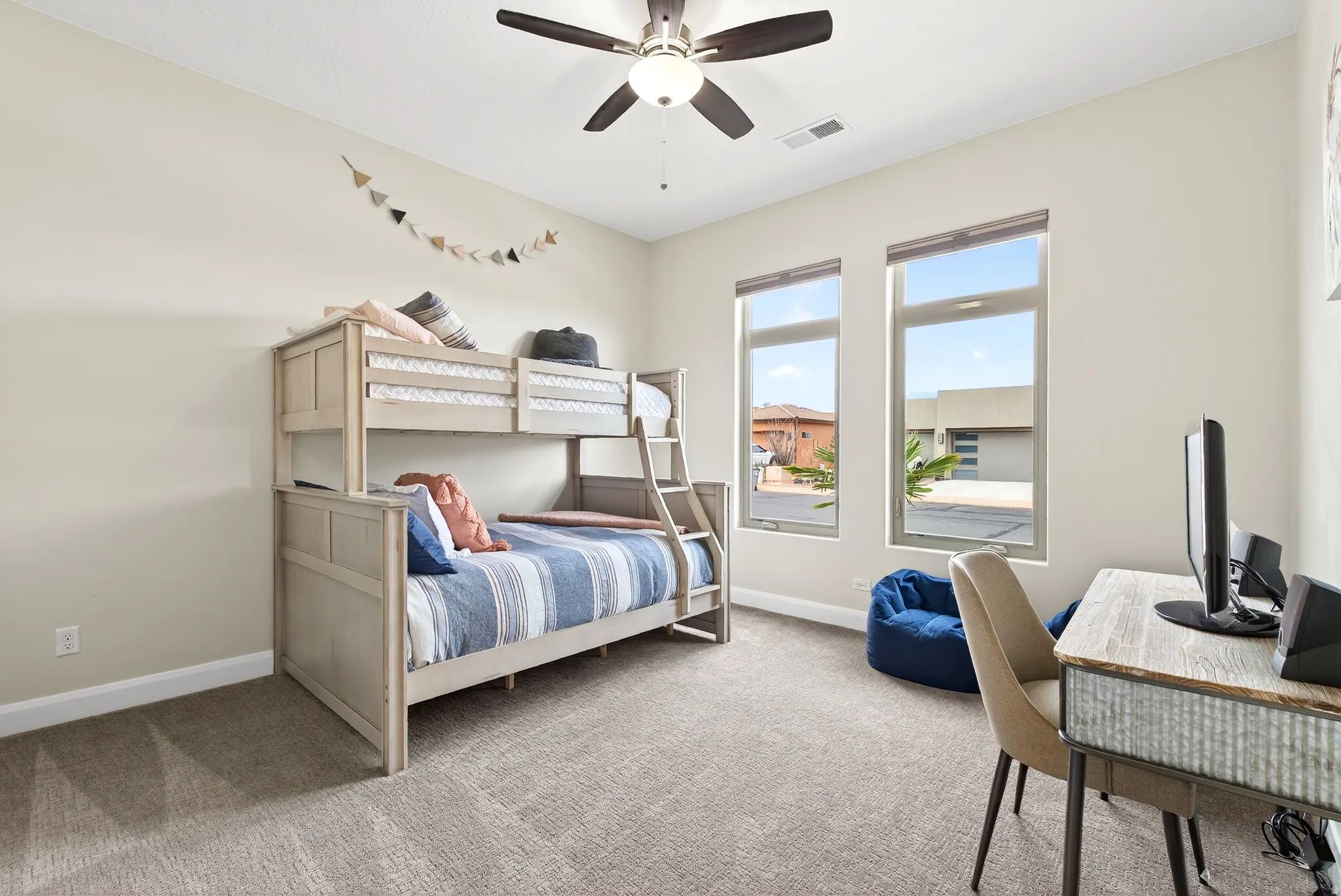 Bedroom featuring light-toned carpeting, neutral wall paint, and a ceiling fan with integrated lighting
