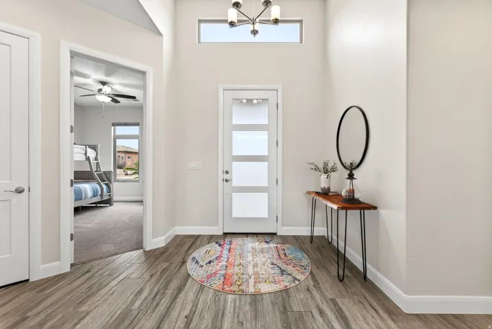 Entryway featuring wood-finish flooring, a modern chandelier, and a transom window