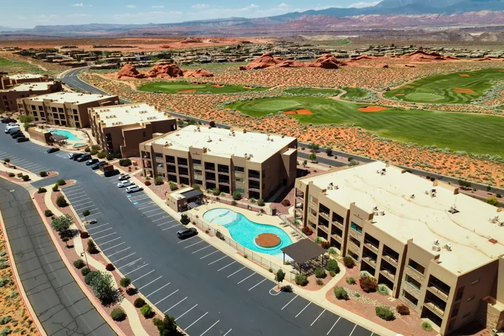 Multi-story buildings featuring private balconies, individual parking spaces, and direct access to two distinct swimming pools with integrated lounge areas