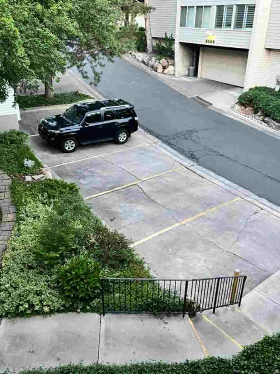 extra street-level parking area featuring concrete surfaces and a paved roadway