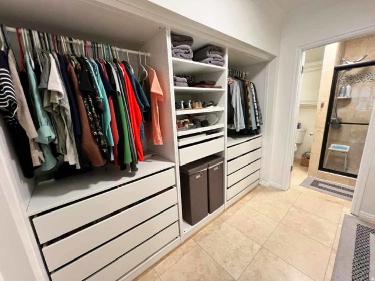 Custom closet system featuring built-in shelving, multiple hanging rods, and integrated drawers