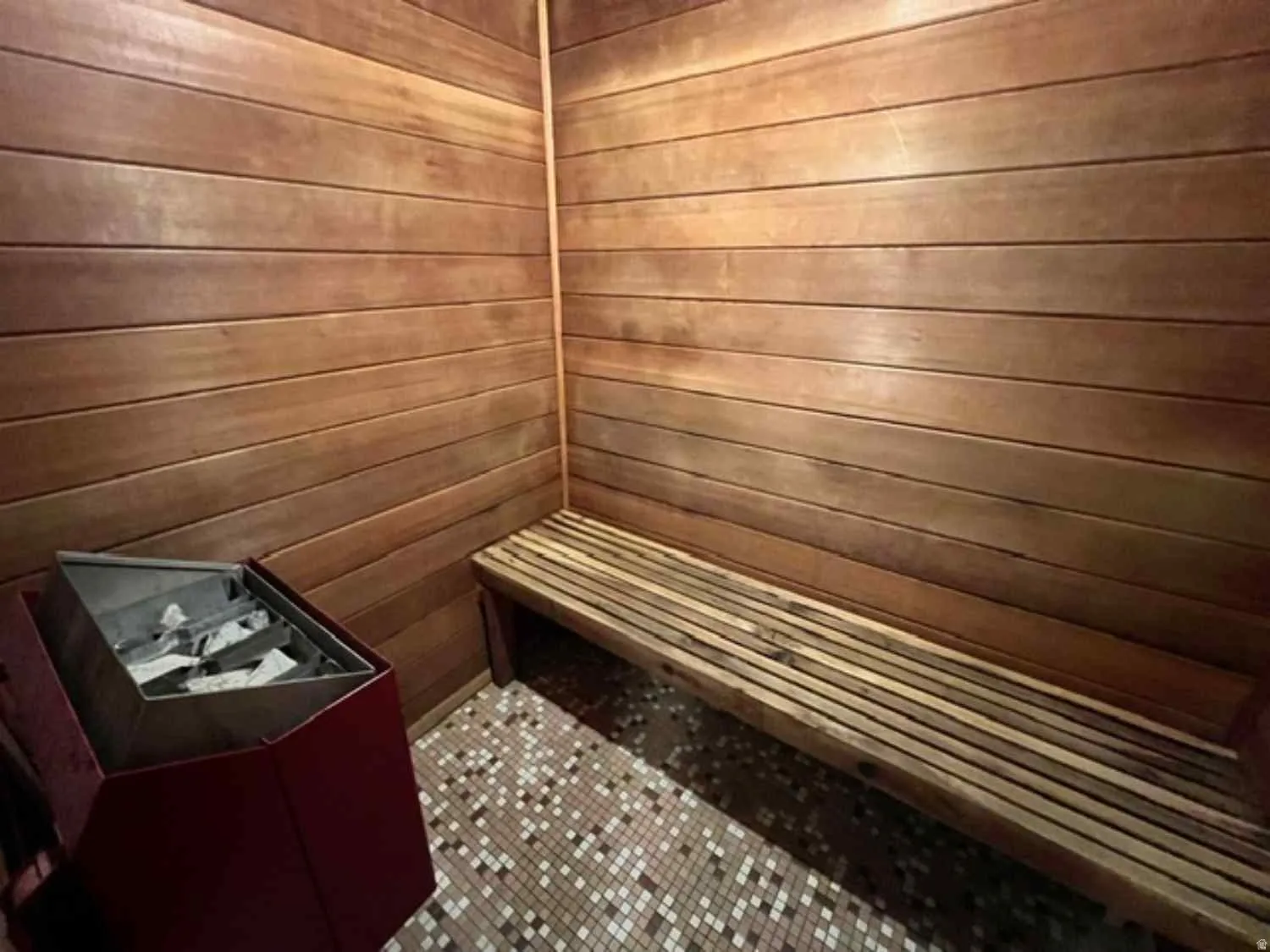 Interior sauna featuring wood-paneled walls and a built-in wooden slatted bench