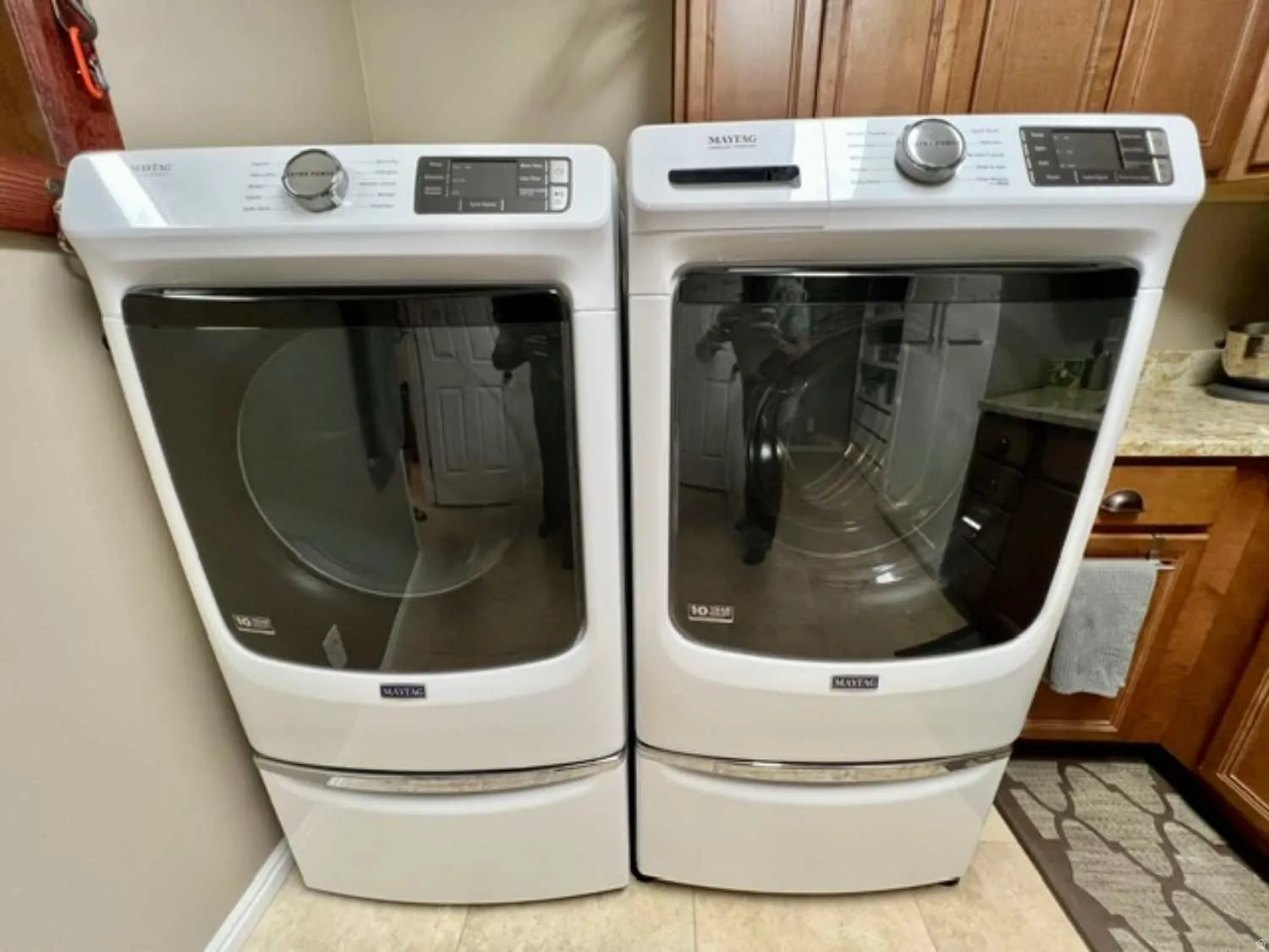 Pair of white front-loading laundry machines on pedestals