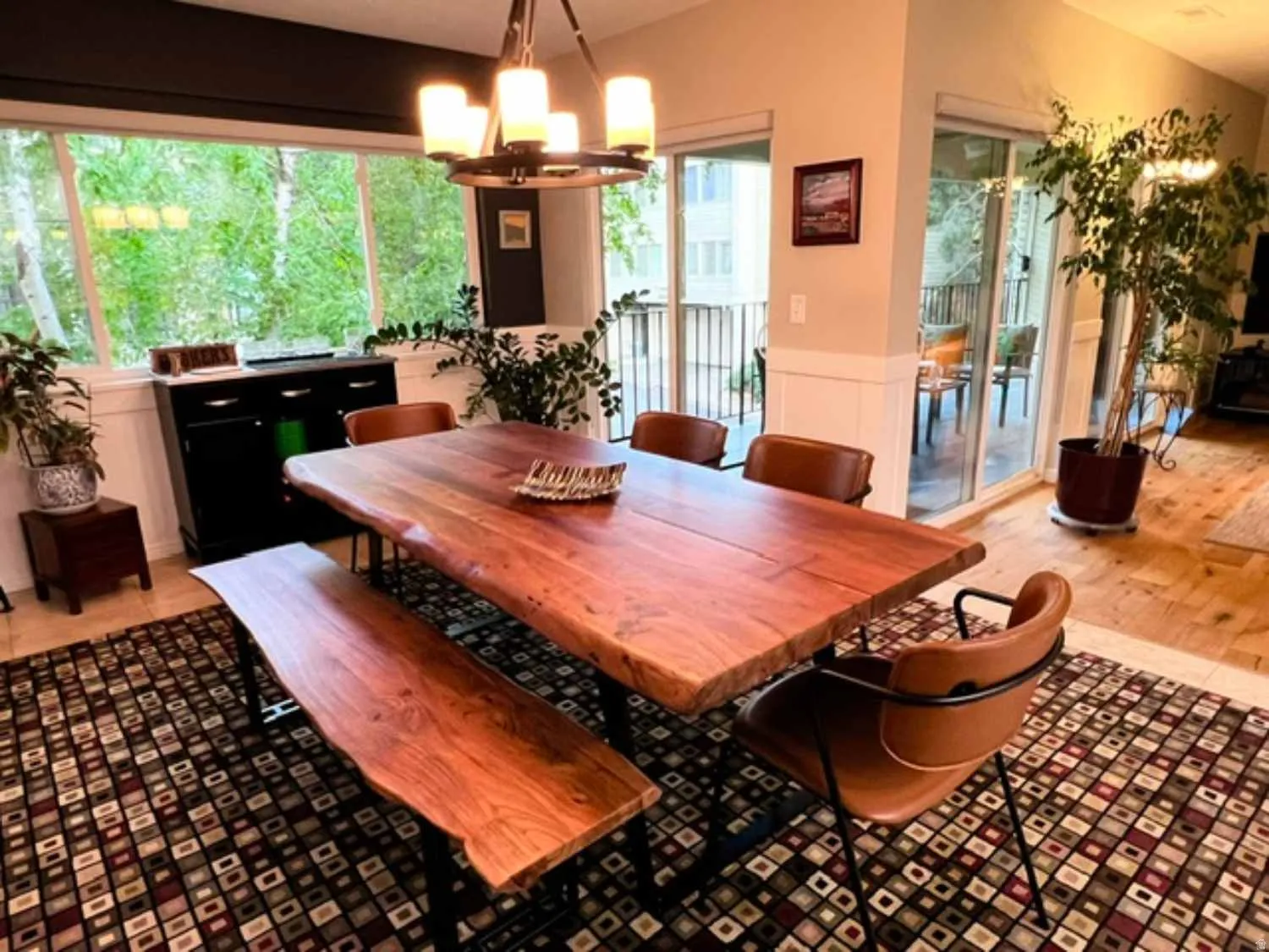 Dining area featuring expansive windows, wood-finish flooring, and a sliding glass door leading to an outdoor space