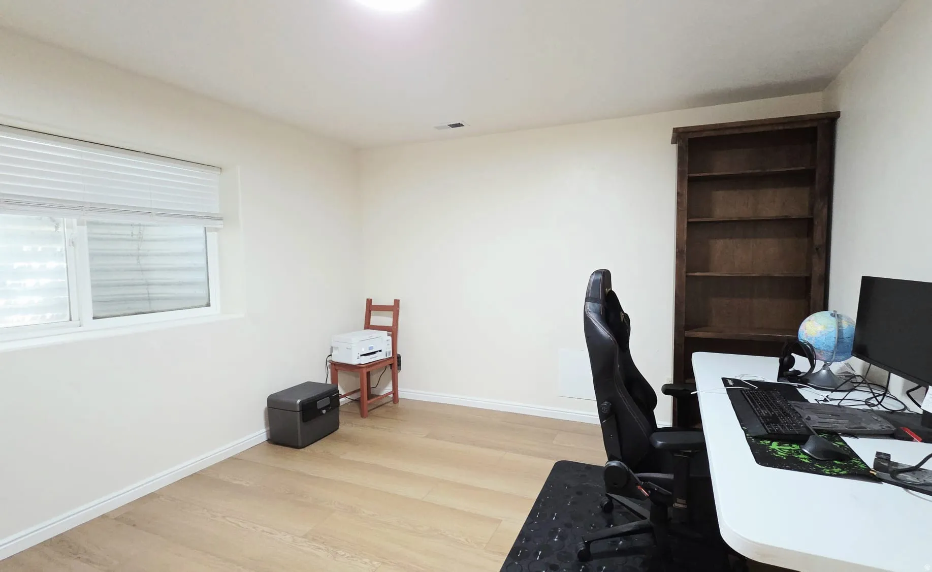 Room with wood-finish flooring, white walls, and a recessed ceiling light
