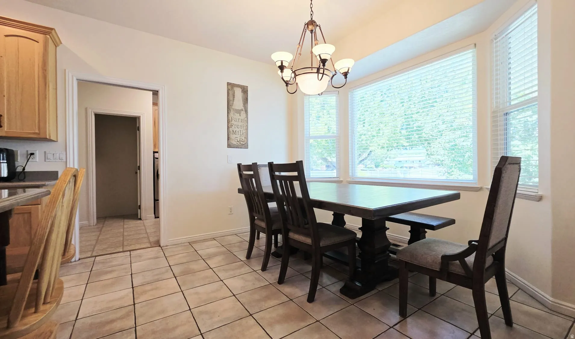 Dining area featuring a bay window, tile flooring, and a chandelier