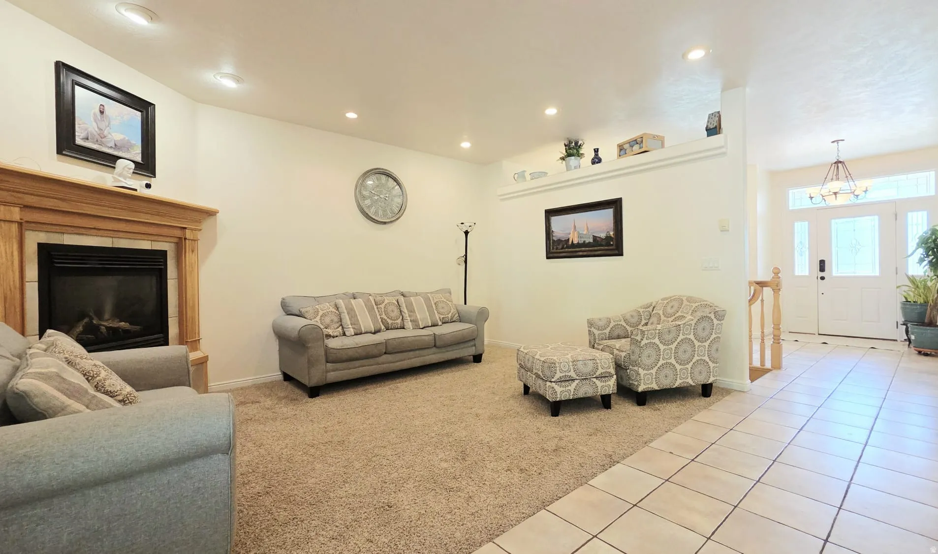 Living area featuring a gas fireplace with a wood mantel, recessed lighting, and carpet flooring
