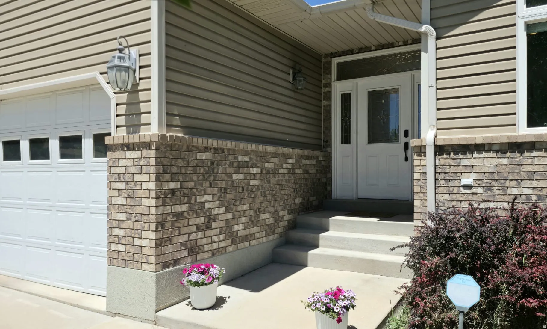 Front entry featuring a white paneled door with sidelights and transom window