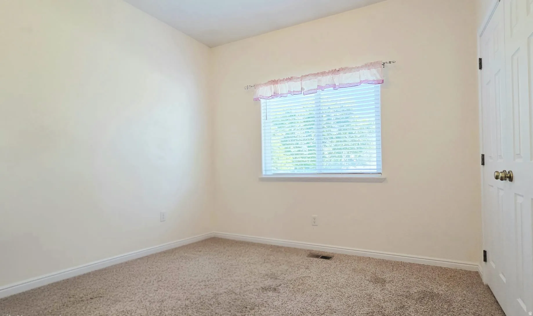 Neutral-toned carpeting paired with light-colored walls and white baseboards