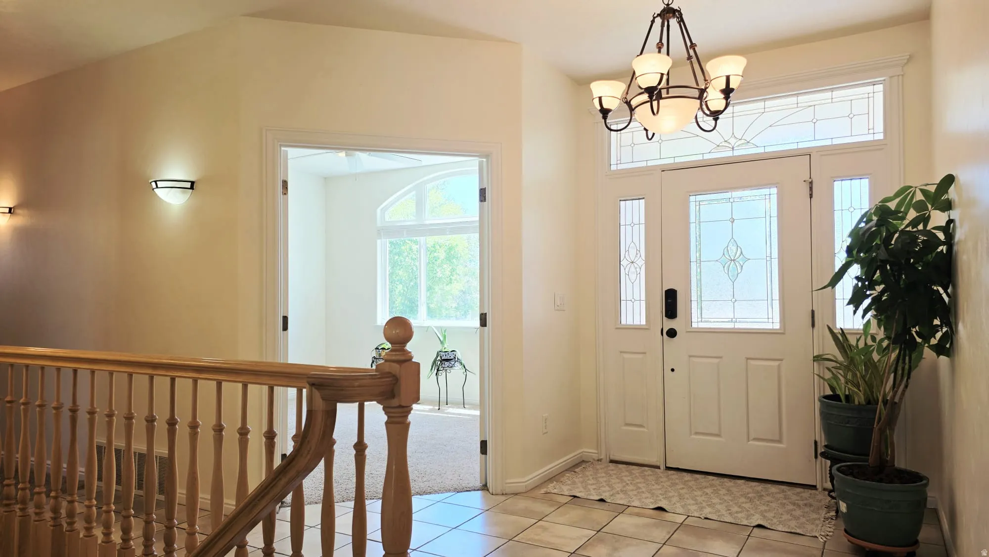 Entry foyer featuring a decorative glass front door, transom window, and sidelights