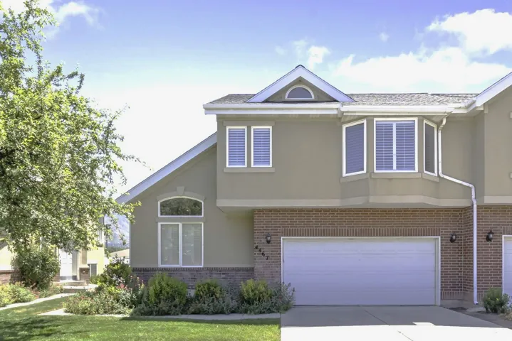 Stucco and brick facade featuring a two-car garage