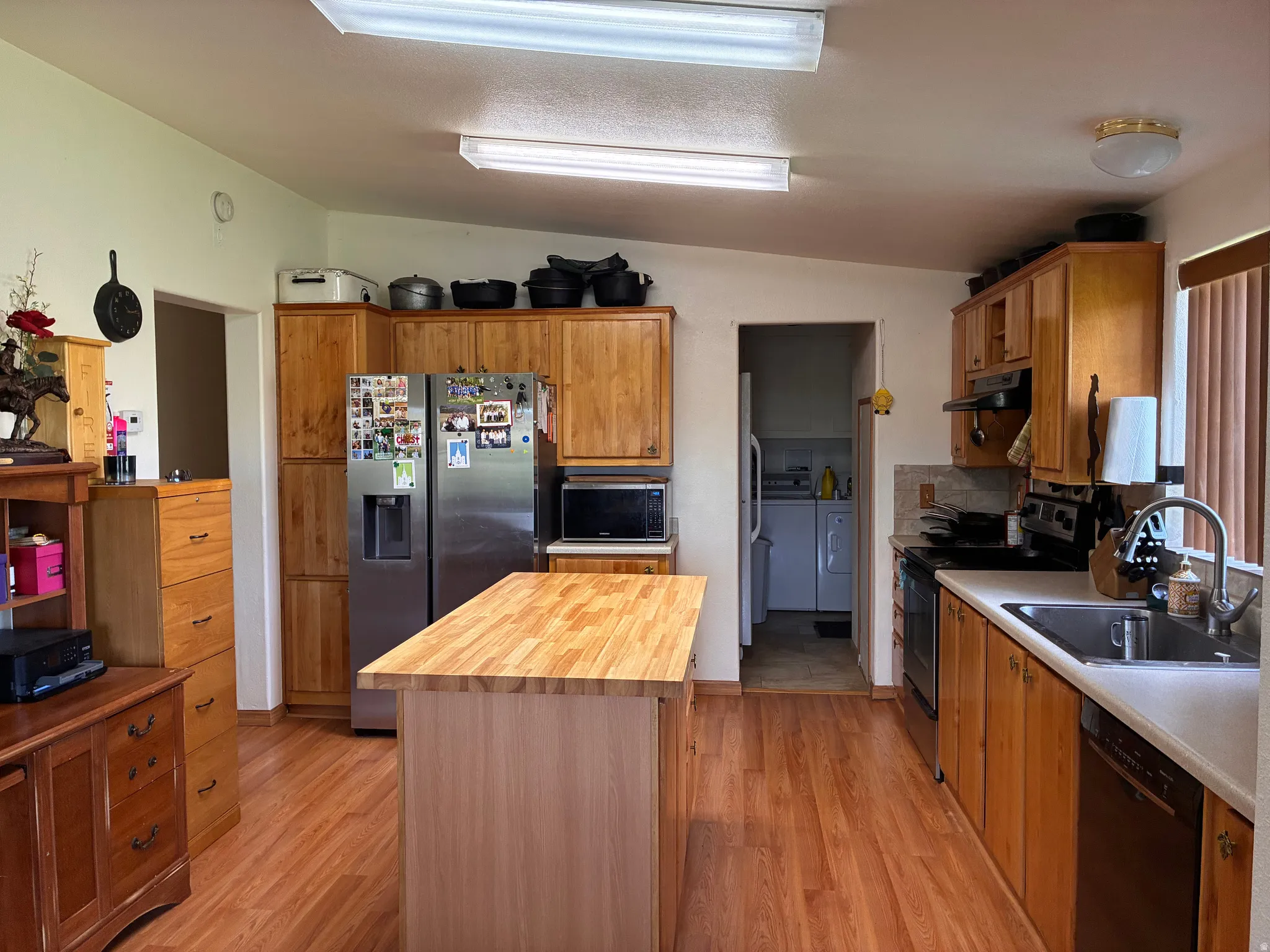 Kitchen with built-in dishwasher, wood cabinets and access to laundry room/mudroom.