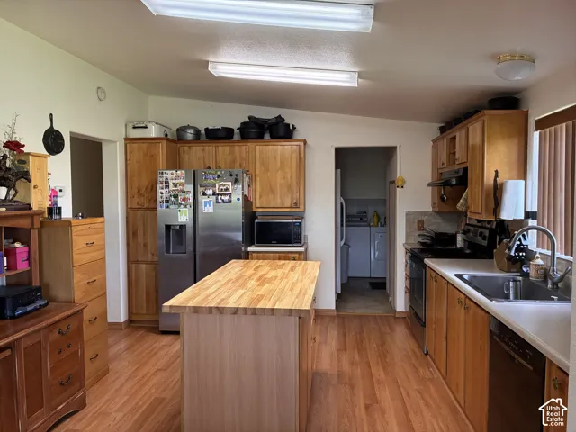Kitchen with built-in dishwasher, wood cabinets and access to laundry room/mudroom.