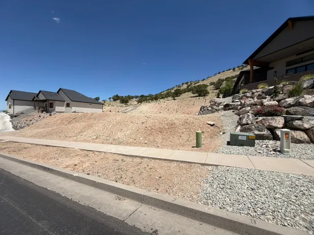 Facing NW.  Expansive graded lot with sidewalk and electrical access and hillside terrain.