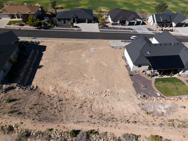 Expansive vacant lot with street frontage, surrounded by established residences