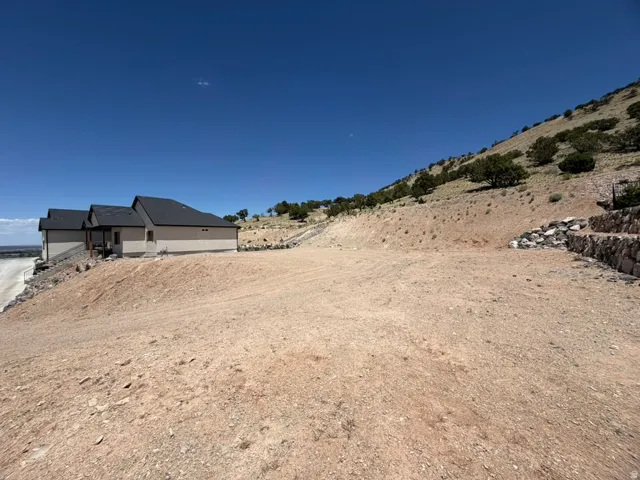 Facing NW.  Expansive graded lot with sloping hillside terrain.
