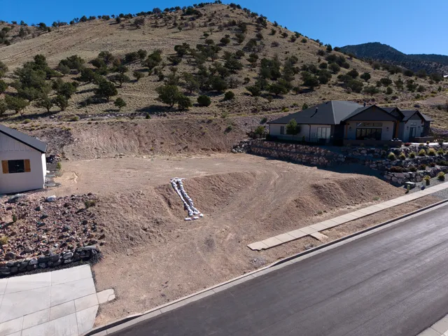 Expansive graded lot featuring a paved street and sidewalk infrastructure