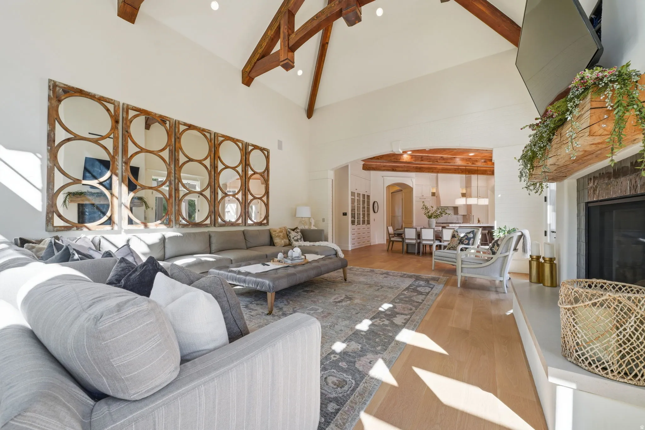 Spacious living area featuring vaulted ceilings with exposed wood beams