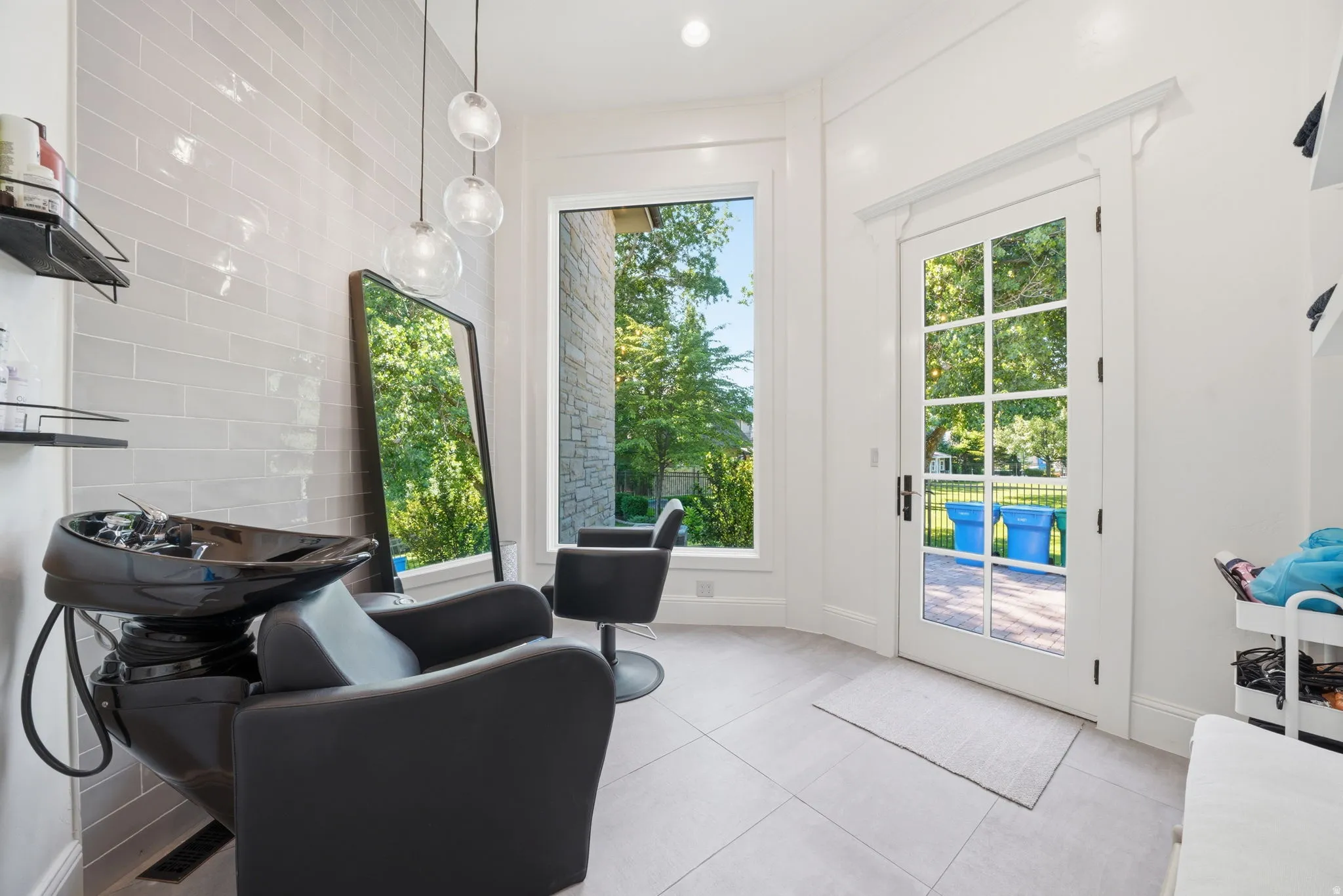 Specialty room featuring light gray subway tile accent wall, pendant lighting, large windows, and a glass-paneled exterior door