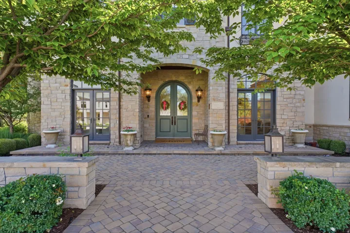 Stone facade with an arched entry and double doors