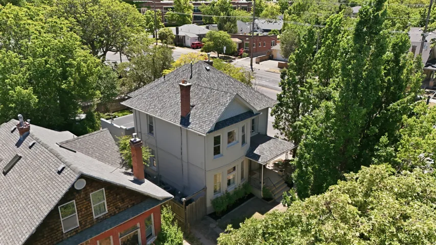 Two-story residence featuring a gabled roof and a prominent brick chimney