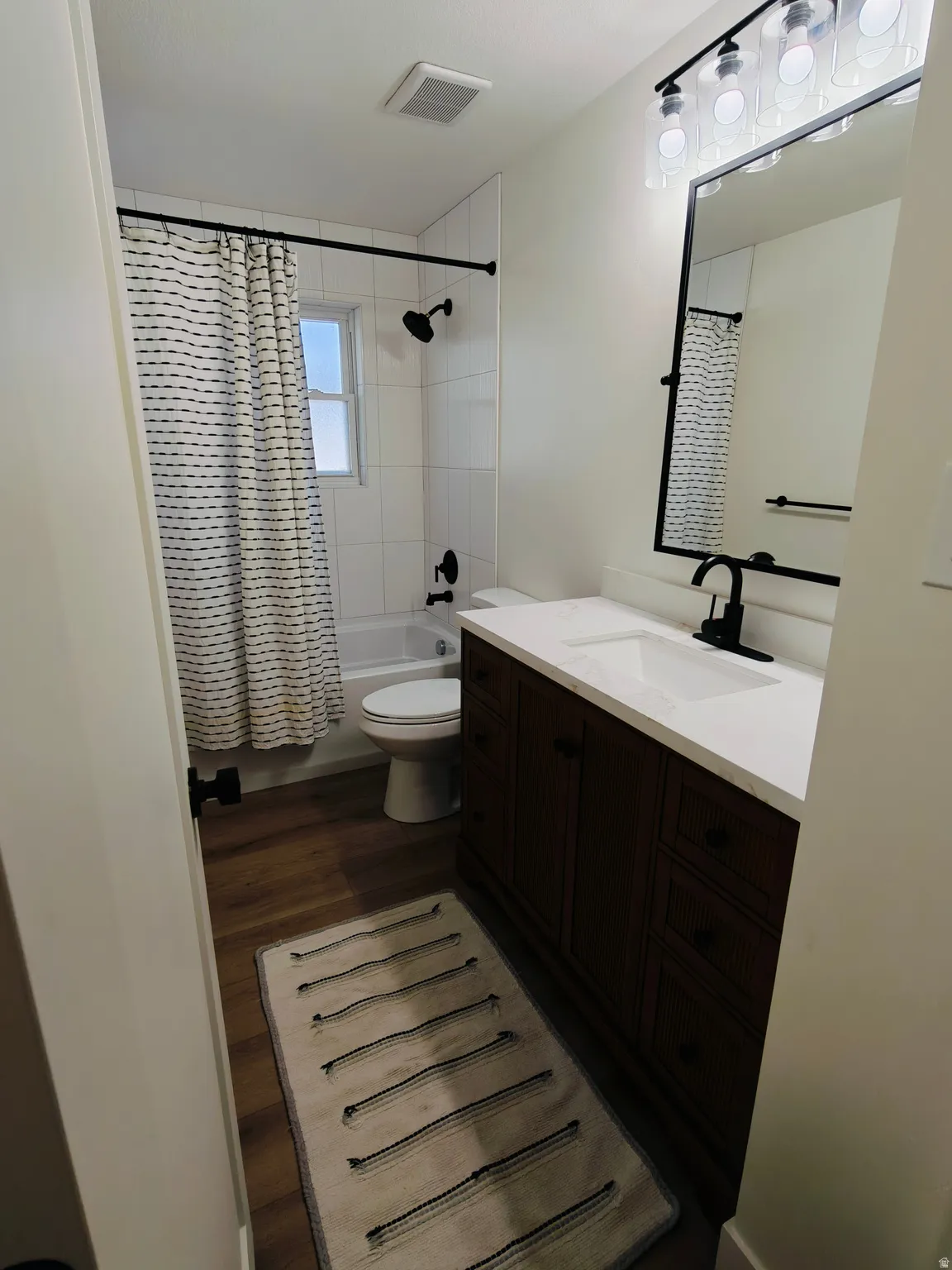 Bathroom featuring a dark wood-finish vanity with a white countertop and integrated sink