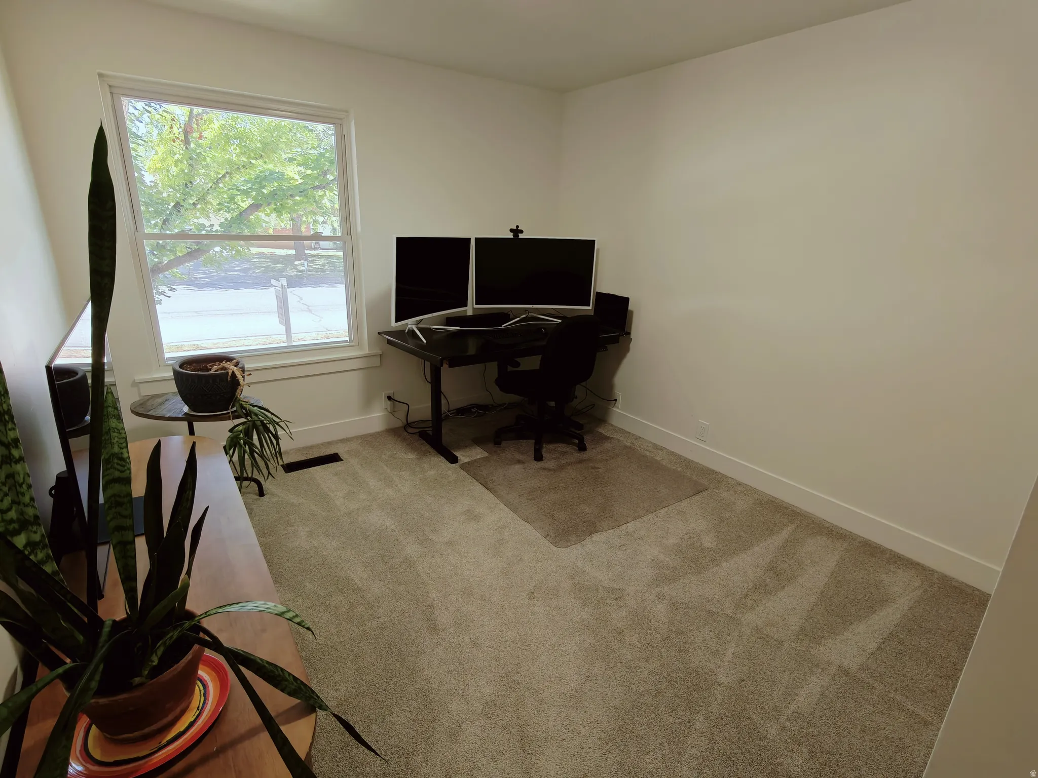 Room featuring neutral wall tones, light-toned carpeting, and a large window with white trim