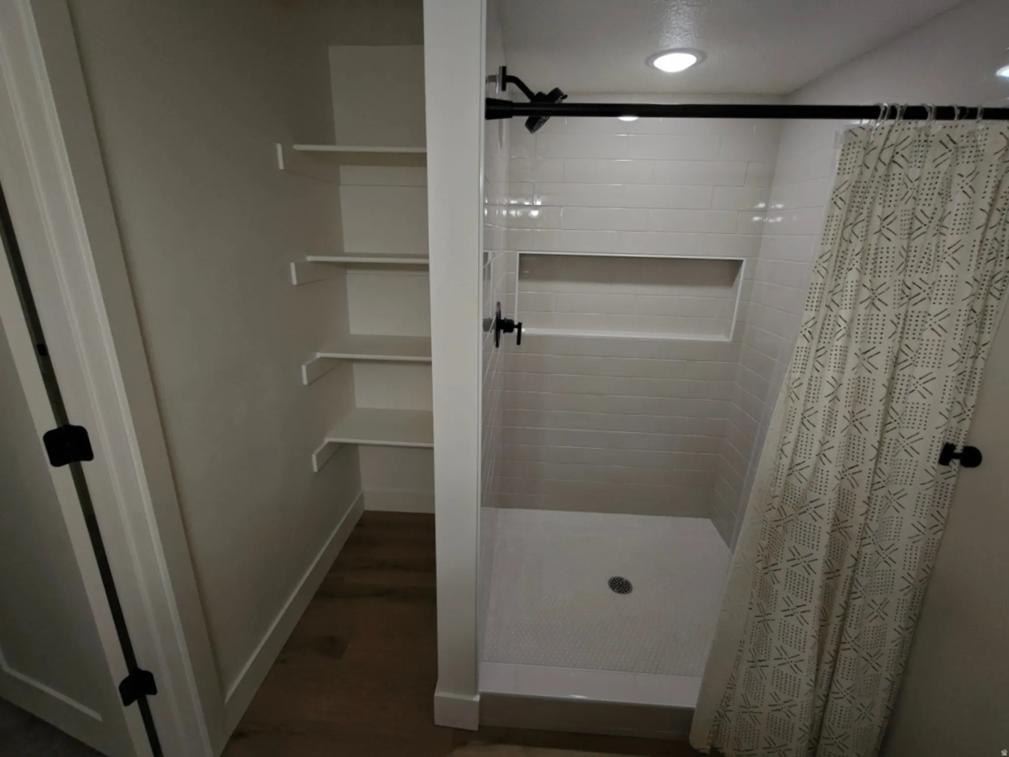 Contemporary shower featuring subway tile surround and a recessed niche