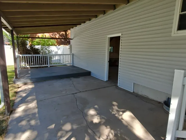 Covered patio area featuring a concrete surface and wood-toned ceiling beams