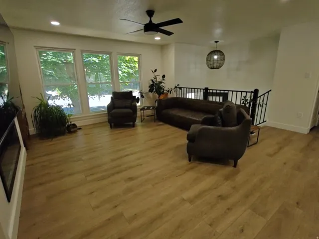Spacious room featuring wood-finish flooring, recessed lighting, and a contemporary ceiling fan
